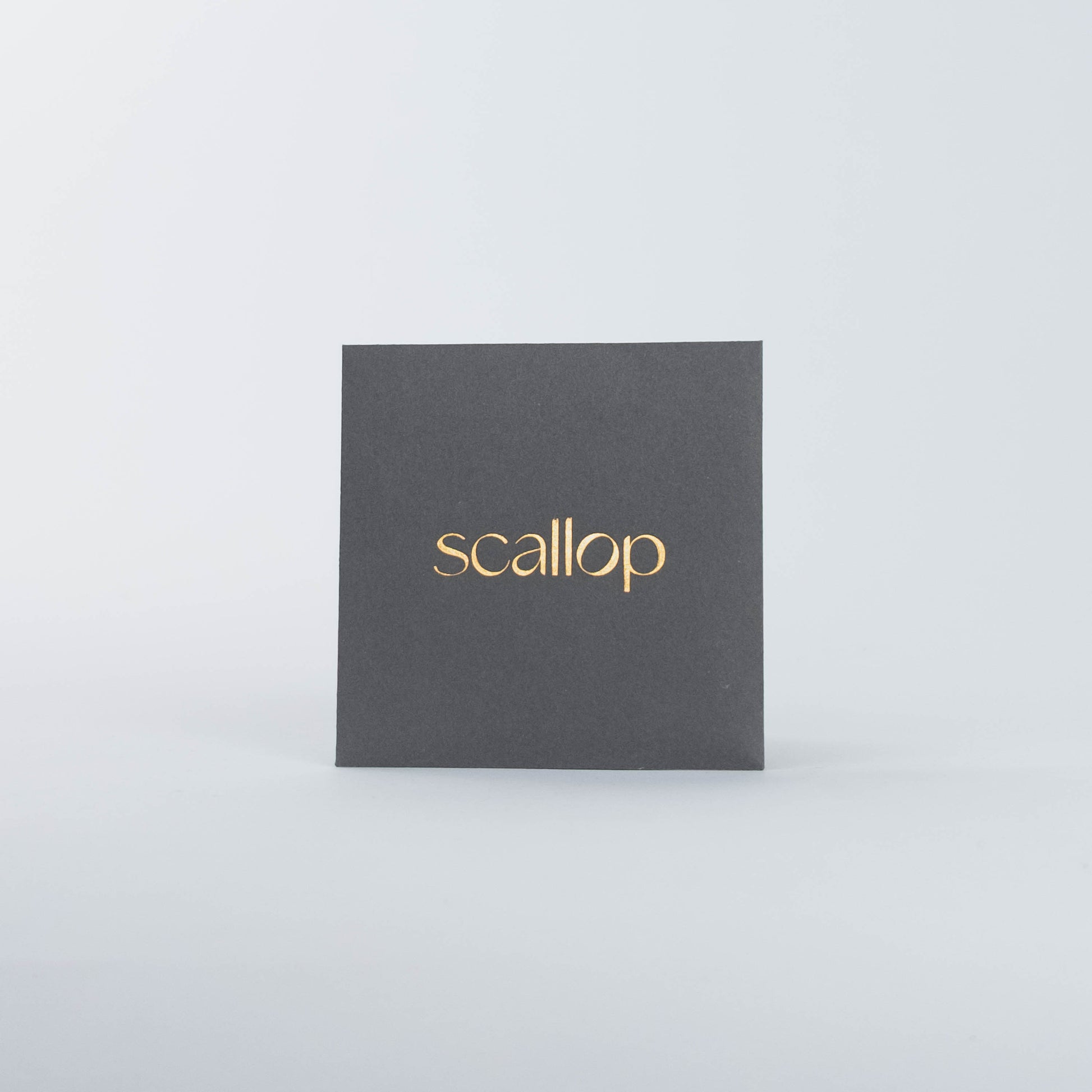 Black square box with gold 'scallop' text on a white background.